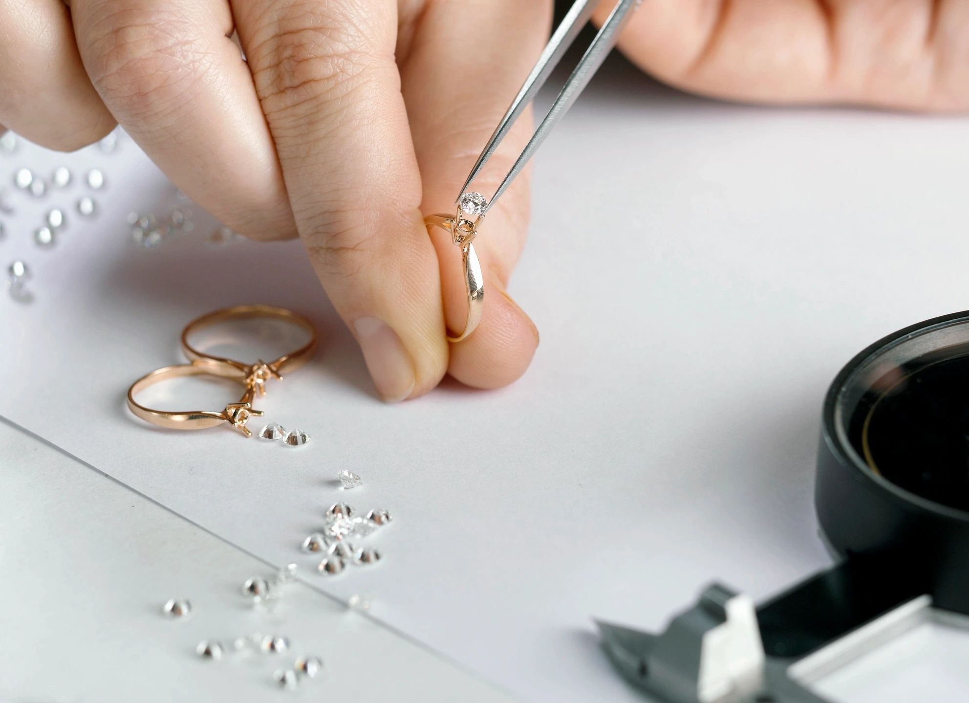 Jeweler placing diamond in ring